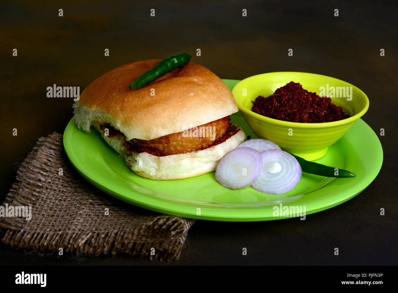 Vada Pav with onion slices green chili and garlic chutney, a popular