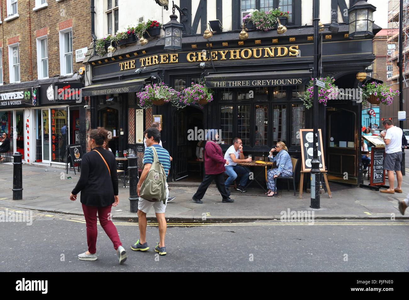 LONDON, UK - JULY 9, 2016: People visit The Three Greyhounds pub in Soho, London. There are more than 7,000 pubs in London. Stock Photo