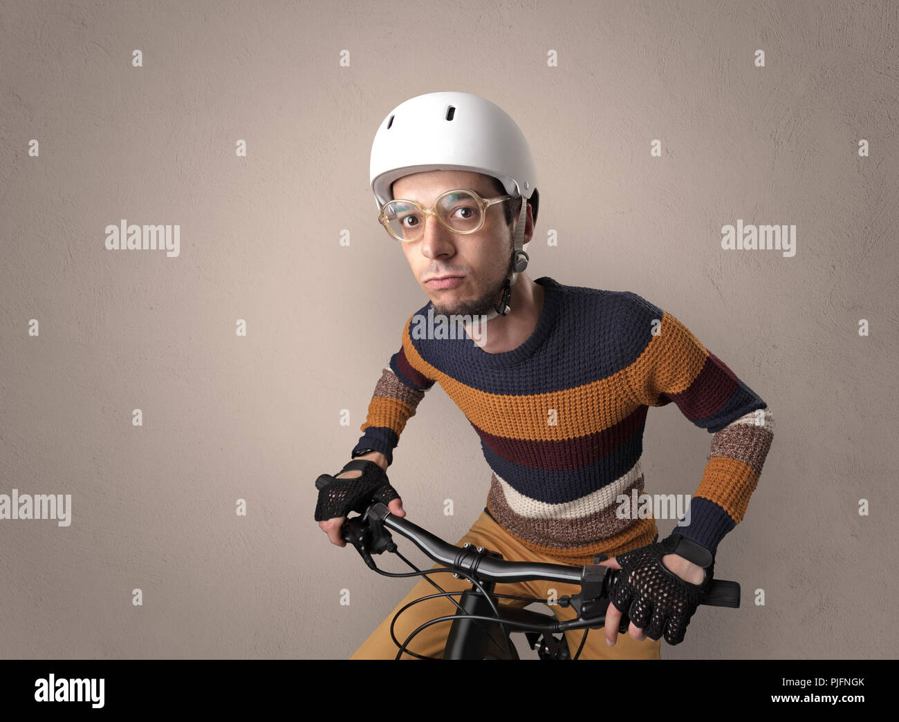 Nerd young foolish biker on a bike with oldschool outfit Stock Photo - Alamy