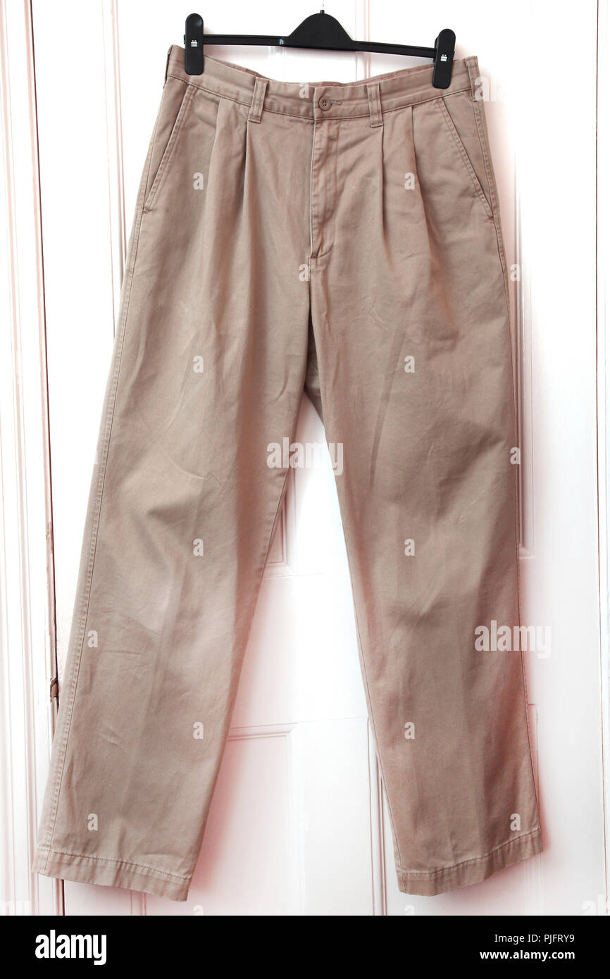 A Pair of Chino Trousers hanging on Door Stock Photo