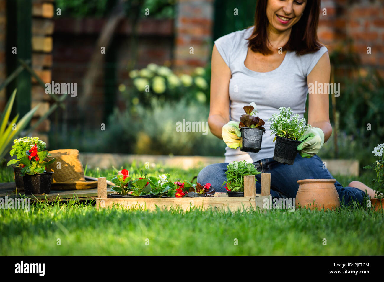 Woman planting flower in her backyard garden Stock Photo - Alamy