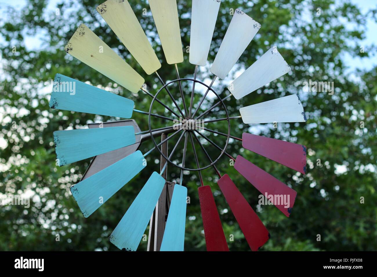 colorful garden windmill with a tree in the background Stock Photo