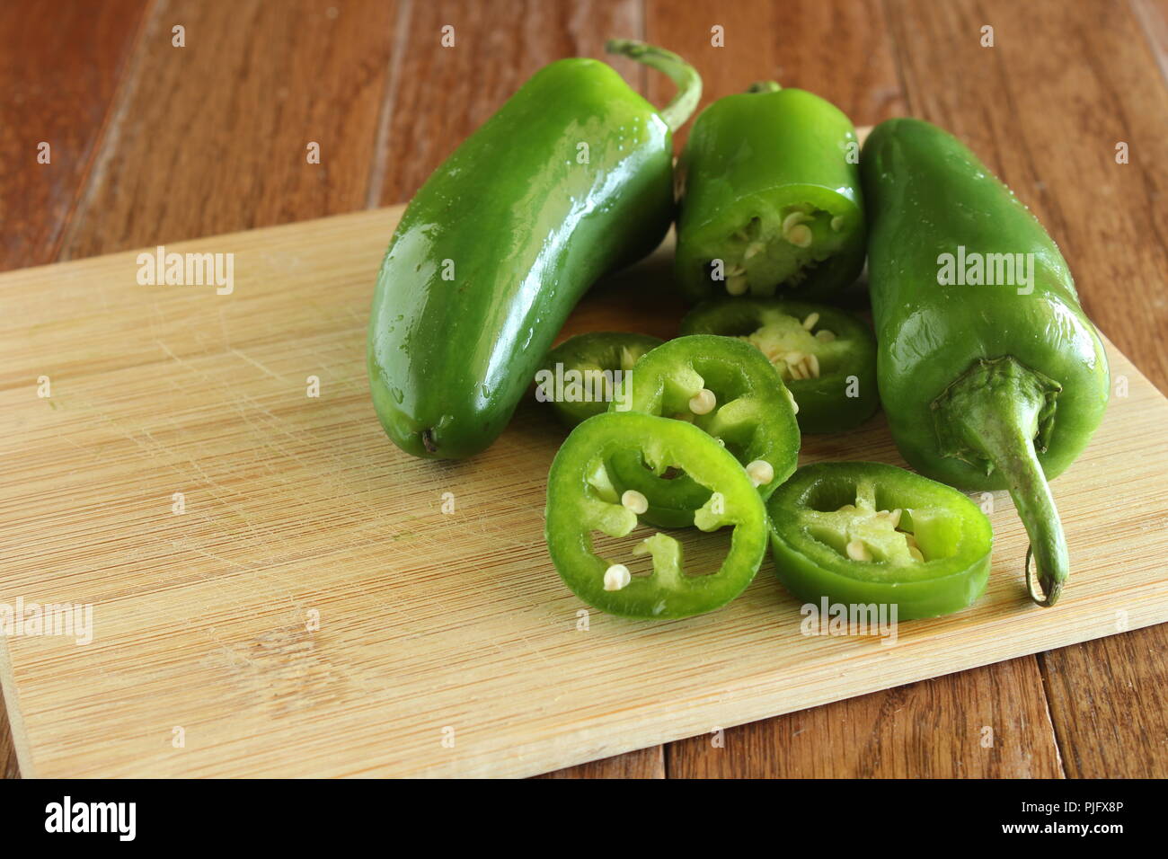 fresh jalapeños sliced on a wooden cutting board Stock Photo