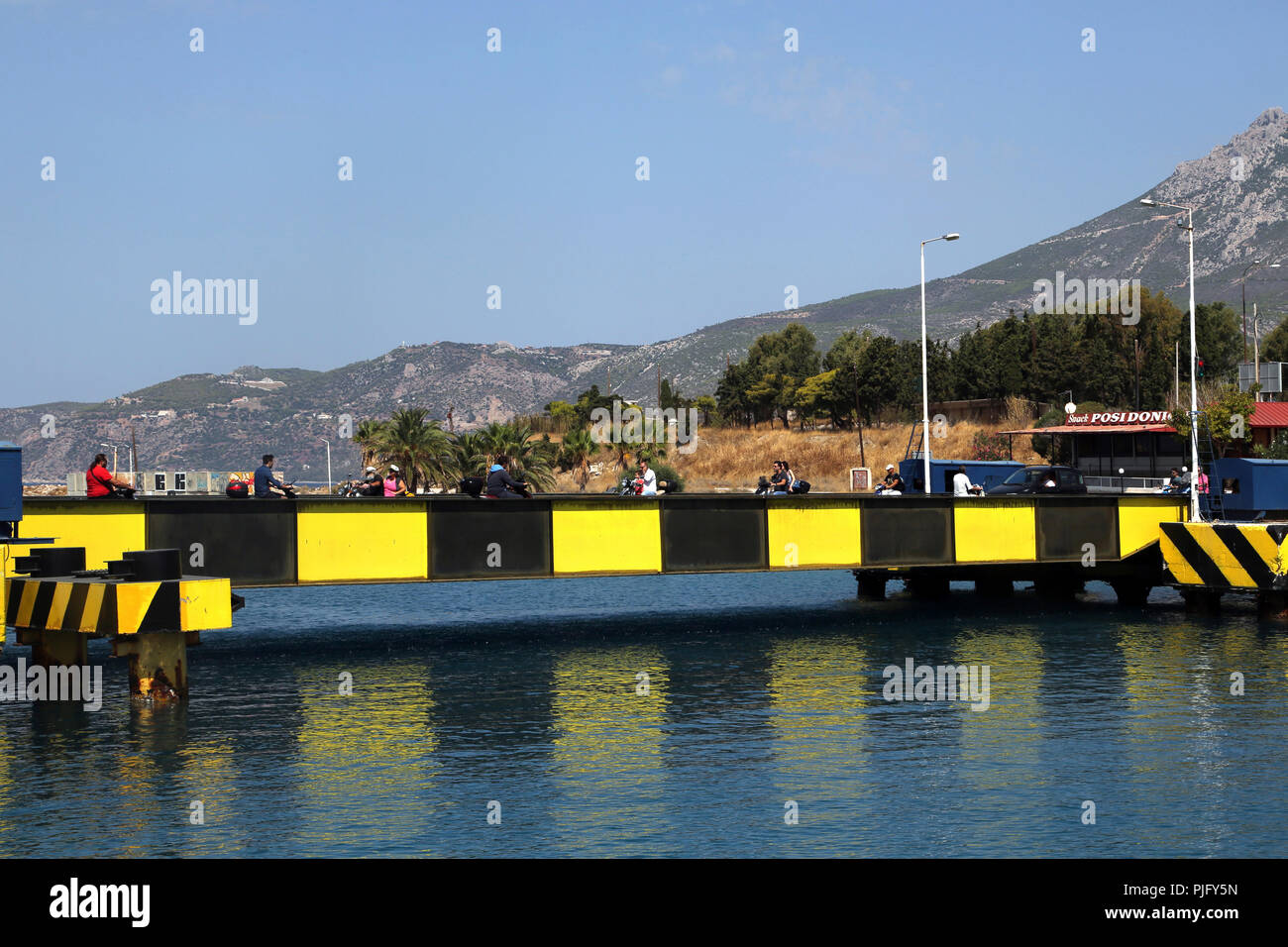 Peloponnese Greece People on Motorbikes Crossing Entrance to Corinth Canal Stock Photo