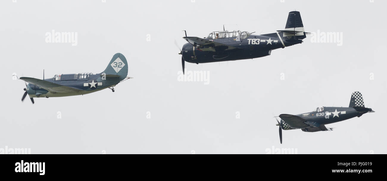 World War II US Navy aircraft flying in formation leader Curtiss SB2C-5 Helldiver, Grumman TBM-3E Avenger and Vought FG-1D Corsair in Thunder Over Mic Stock Photo