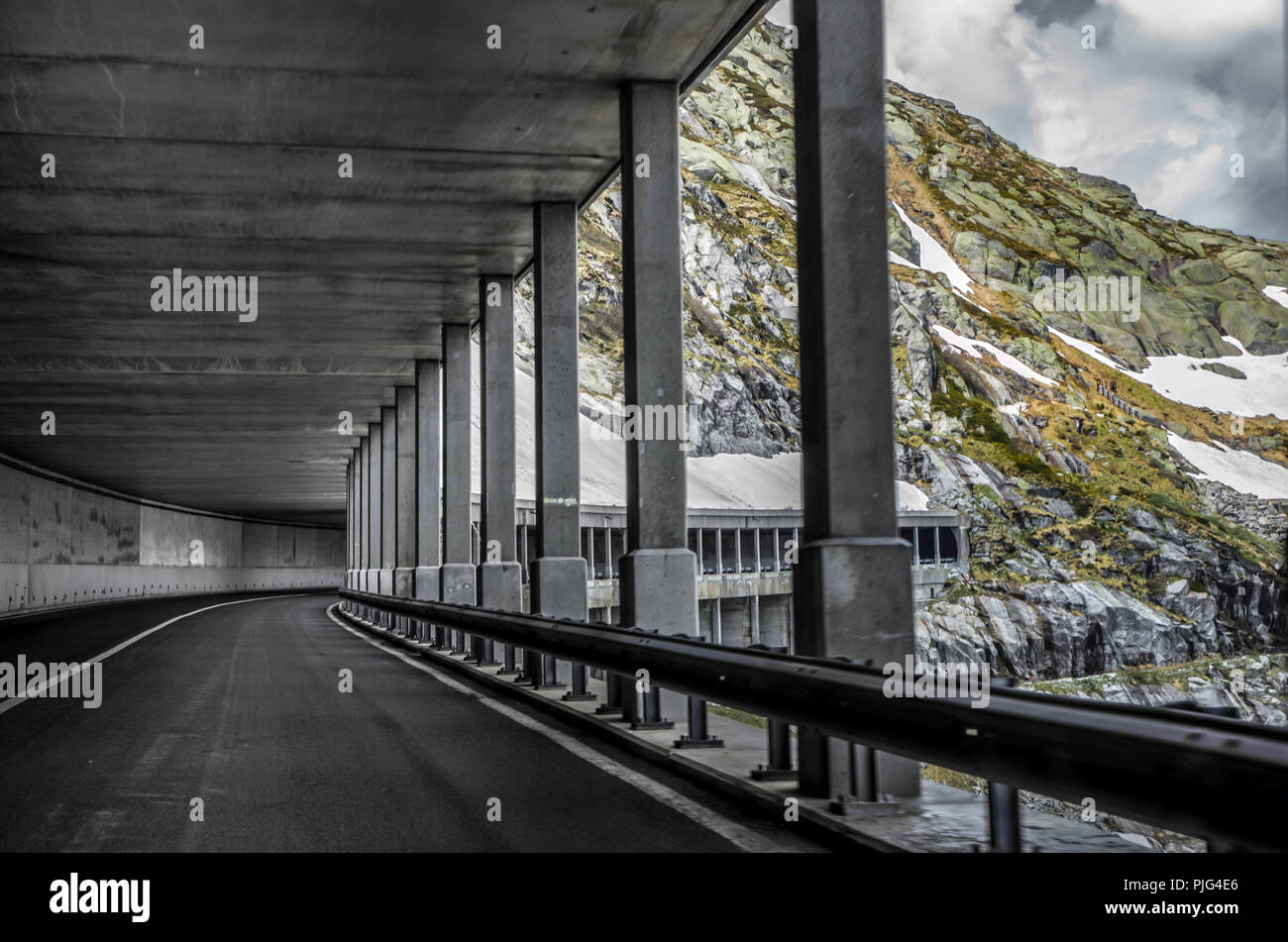 Mountain Road and Open Tunnel with snow in Switzerland. Stock Photo