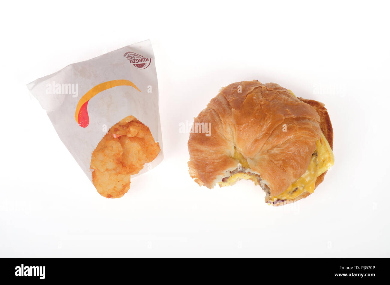 Burger King sausage, egg and cheese croissan’wich or croissant sandwich with hash brown potatoes packet Stock Photo