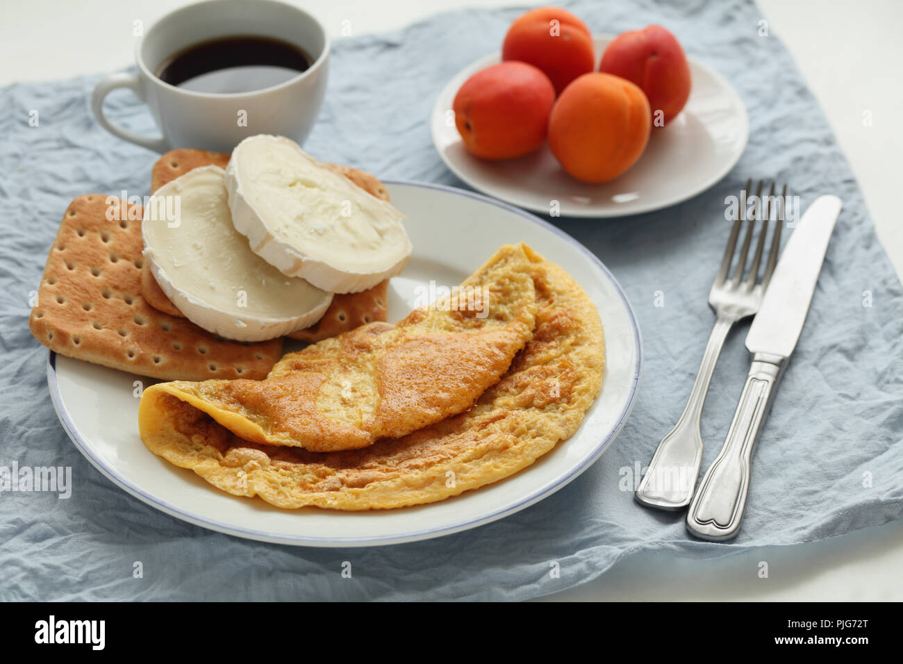 Breakfast with french omelet, goat cheese, black coffee, and apricot fruits Stock Photo