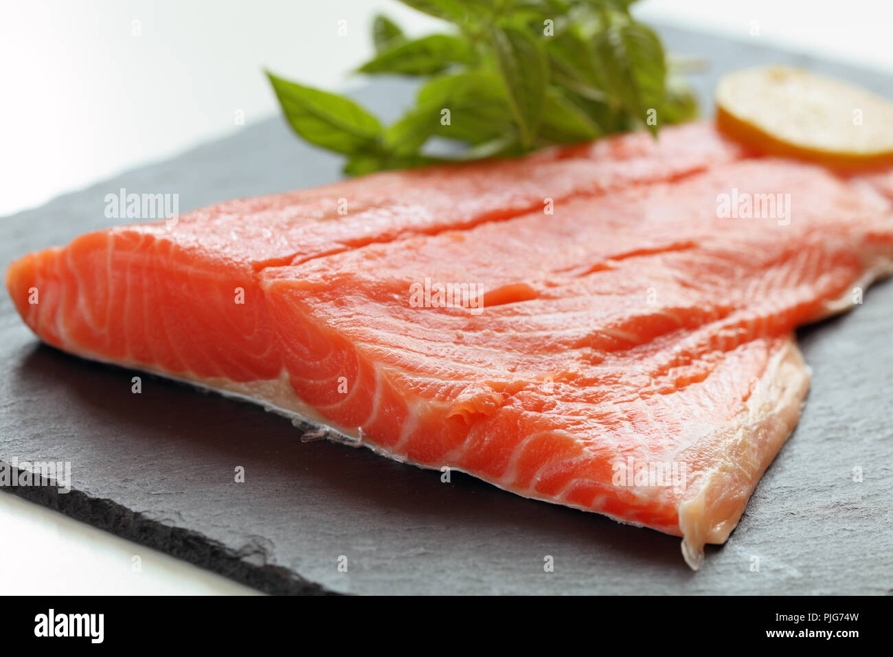 Salmon filet and basil on a slate cutting board Stock Photo - Alamy