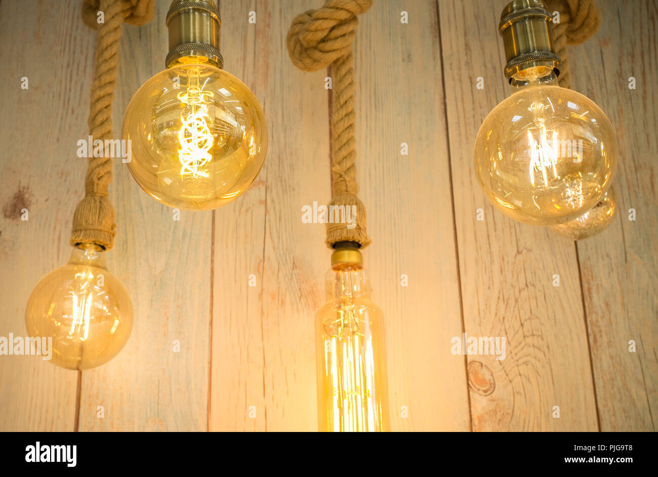 Rope light bulbs over weathered wooden background. Low angle view Stock Photo