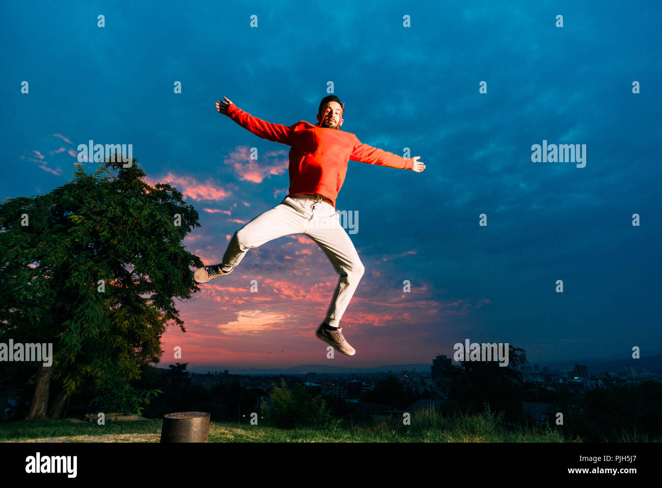 Young man practicing parkour while jumping in park Stock Photo