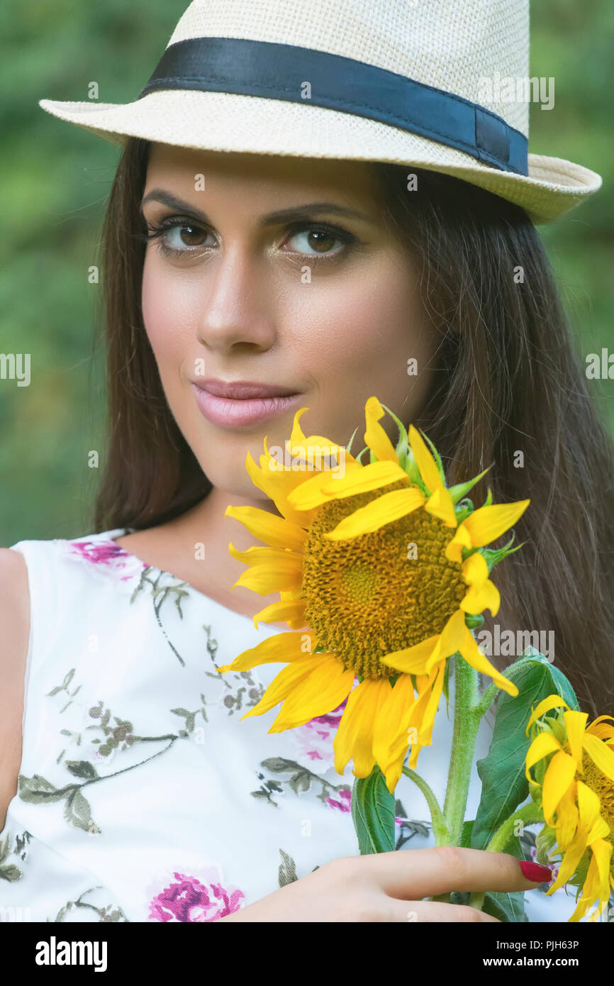 Close-up portrait of brunette woman with sunflower in her hand Stock ...