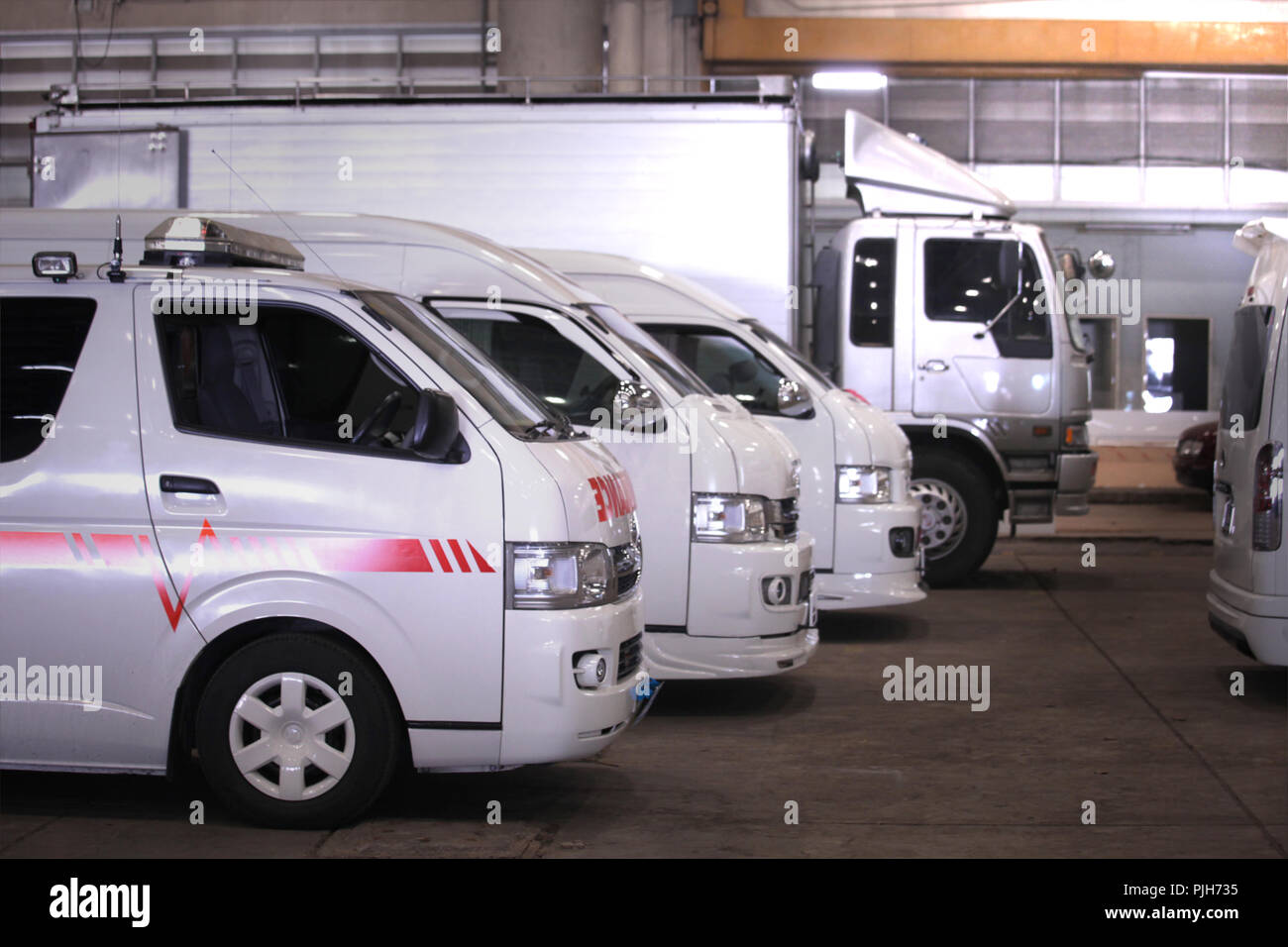 a lot of vans and truck for rent in case of emergency and for  transportation parking in big garage Stock Photo - Alamy