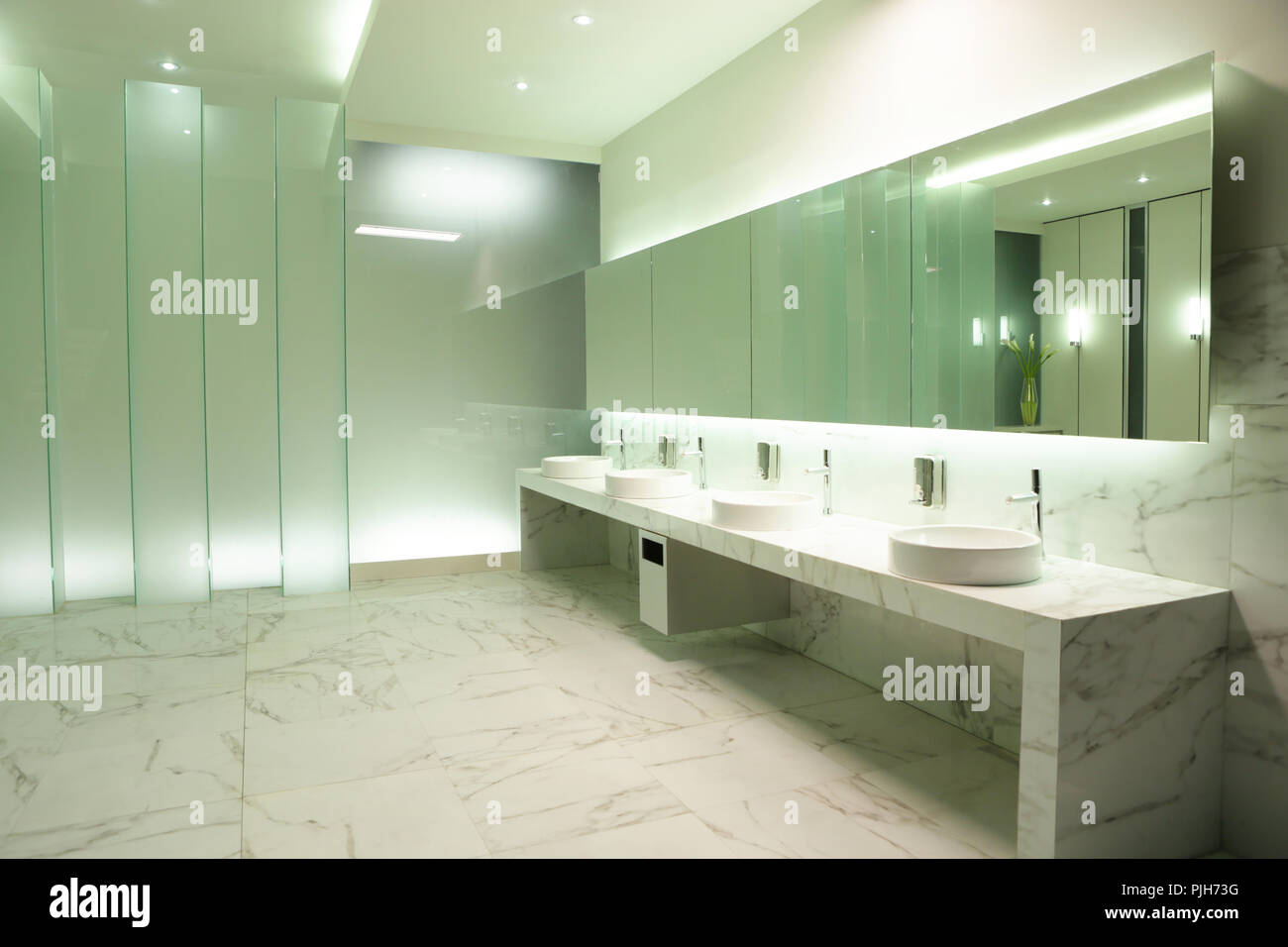 the clear mirror in elegant public restroom setup reflect the door of ...