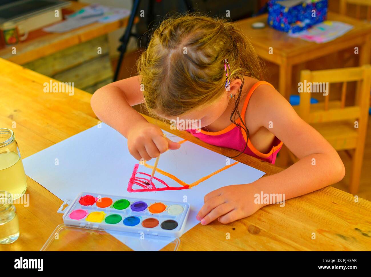 Little girl painting simple picture. Cute girl painting with
