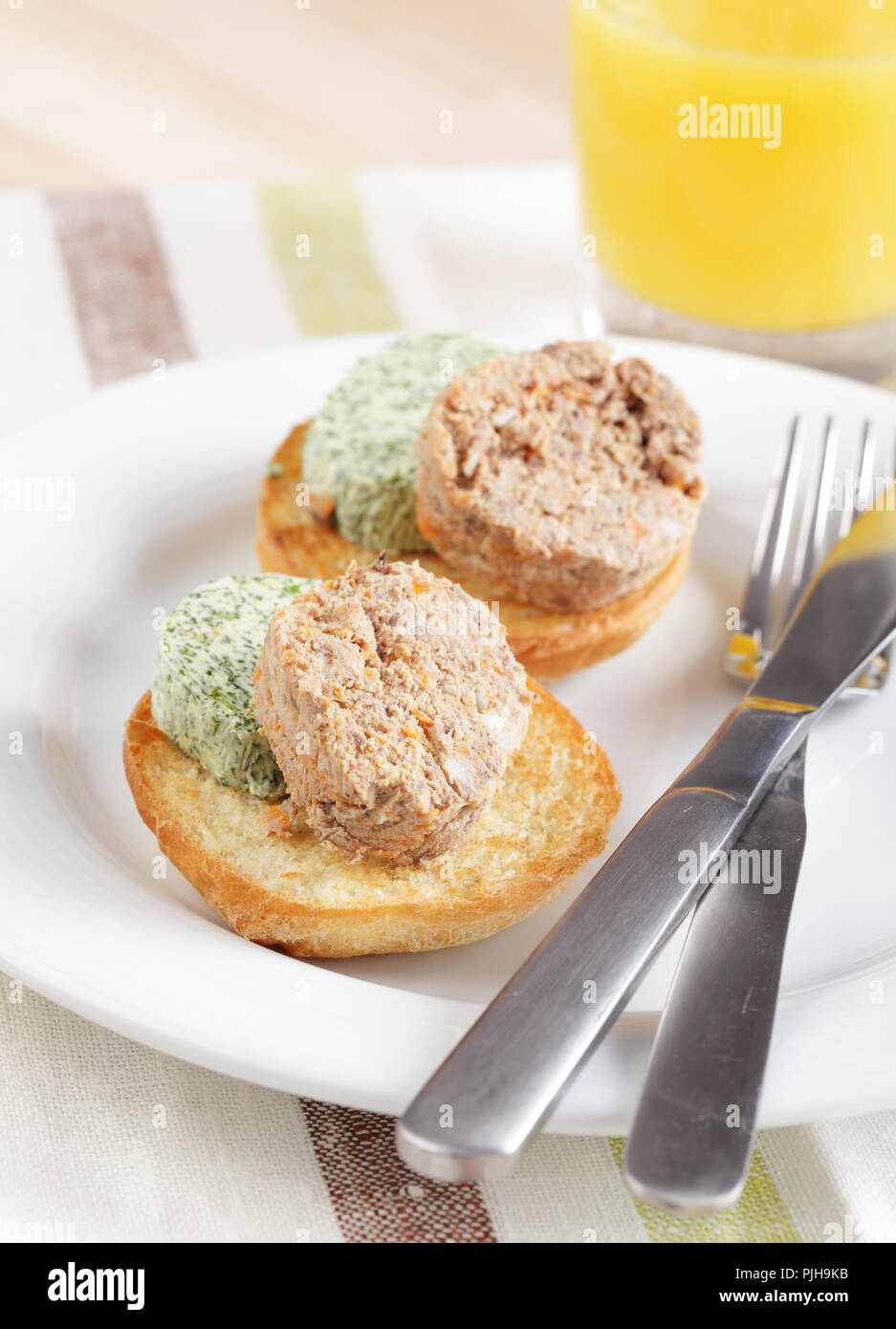 Breakfast with liver pate and green butter on the toasted bun Stock