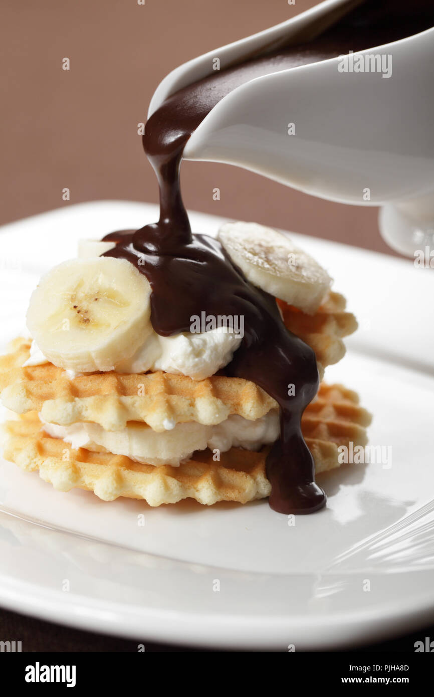 Waffle with Greek yogurt and banana under chocolate sauce closeup Stock ...
