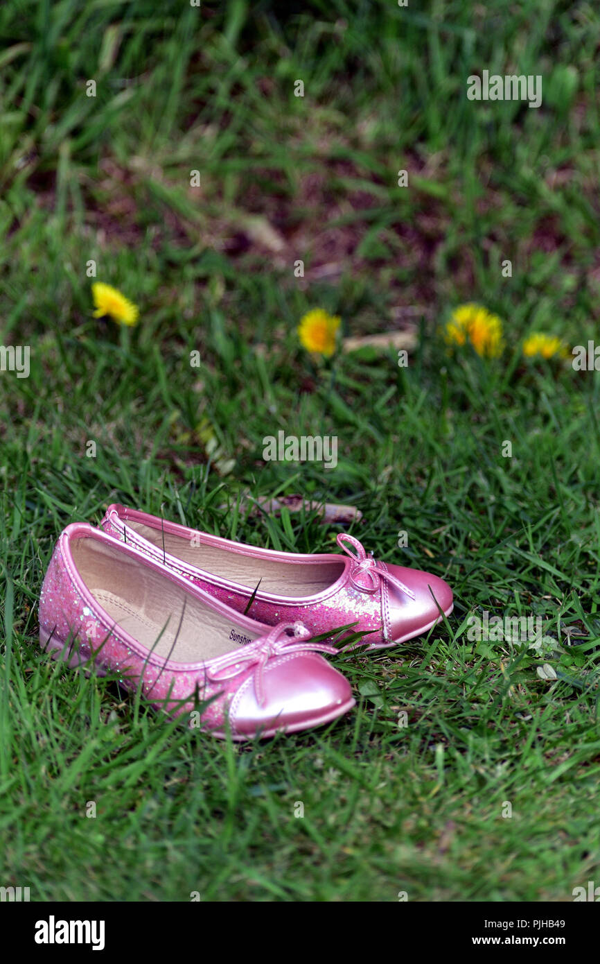 Pretty girl pink shoes on grass during spring season (every girl deserves good shoes to go to good places) Stock Photo