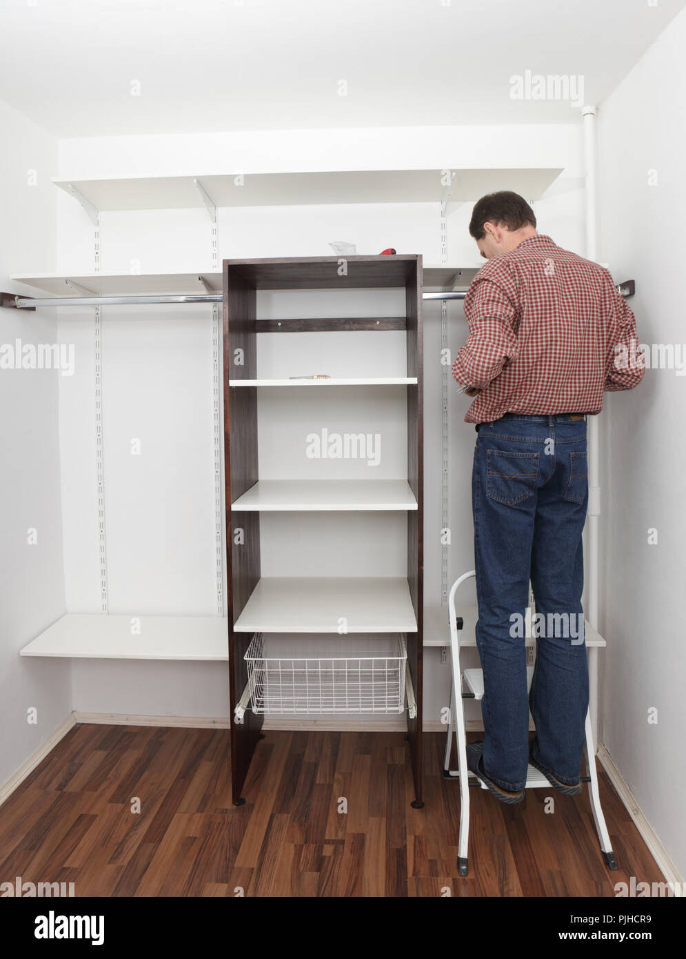 Man assembling the closet with wooden shelves Stock Photo - Alamy