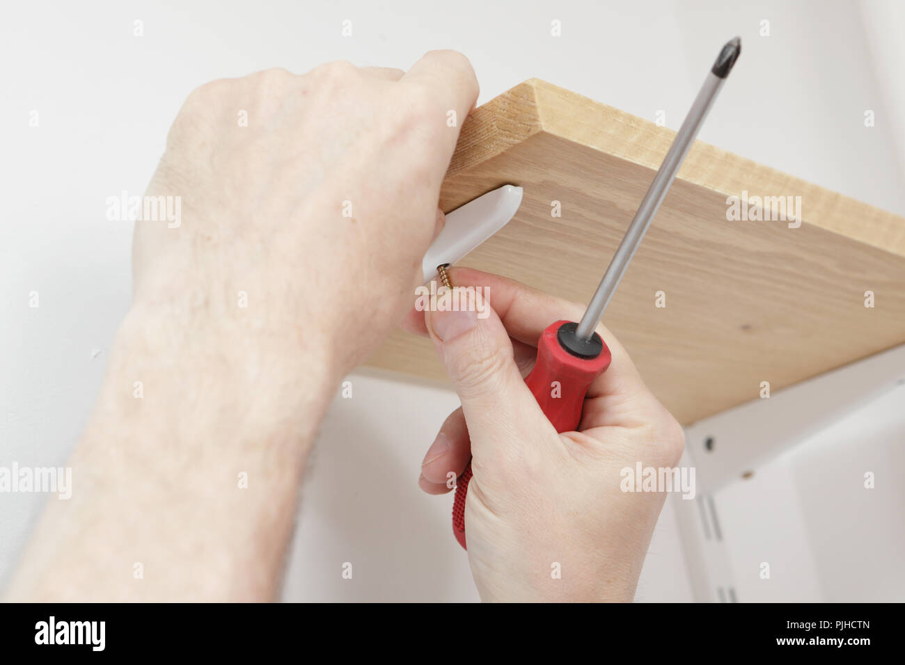 Man installing wooden shelves on brackets Stock Photo Alamy