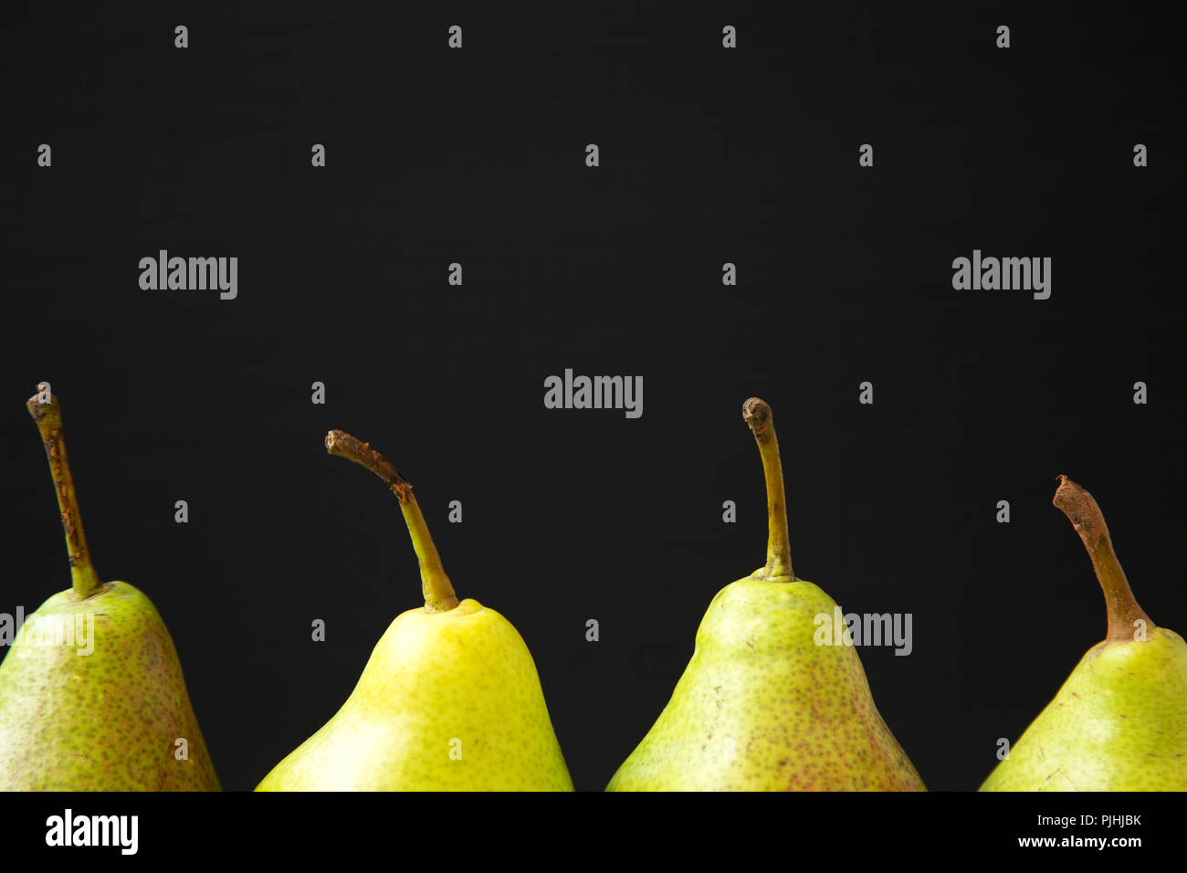 Pear Side View Fresh pears against black background, side view. Close-up. Organic ...