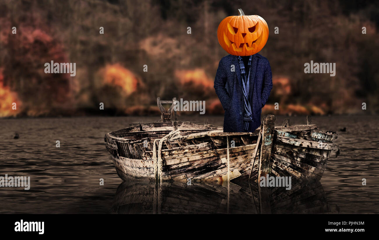 Halloween scary pumpkin headed ghost person on a boat floating Stock Photo