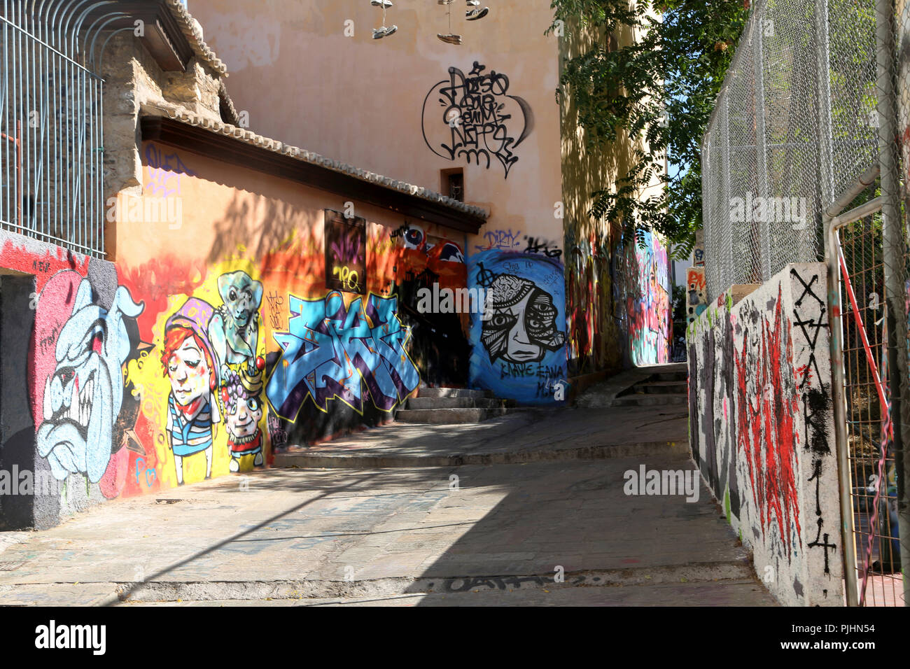 Plaka Athens Greece Street Scene Graffiti on Walls of Buildings and Shoes hanging high on Wire Stock Photo