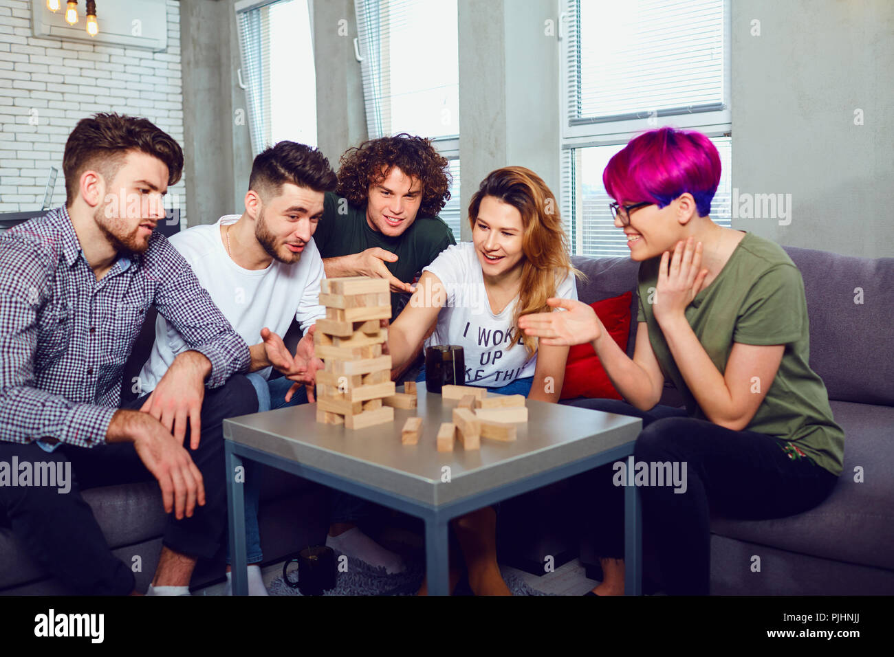 A group of friends play board games in the room. Stock Photo