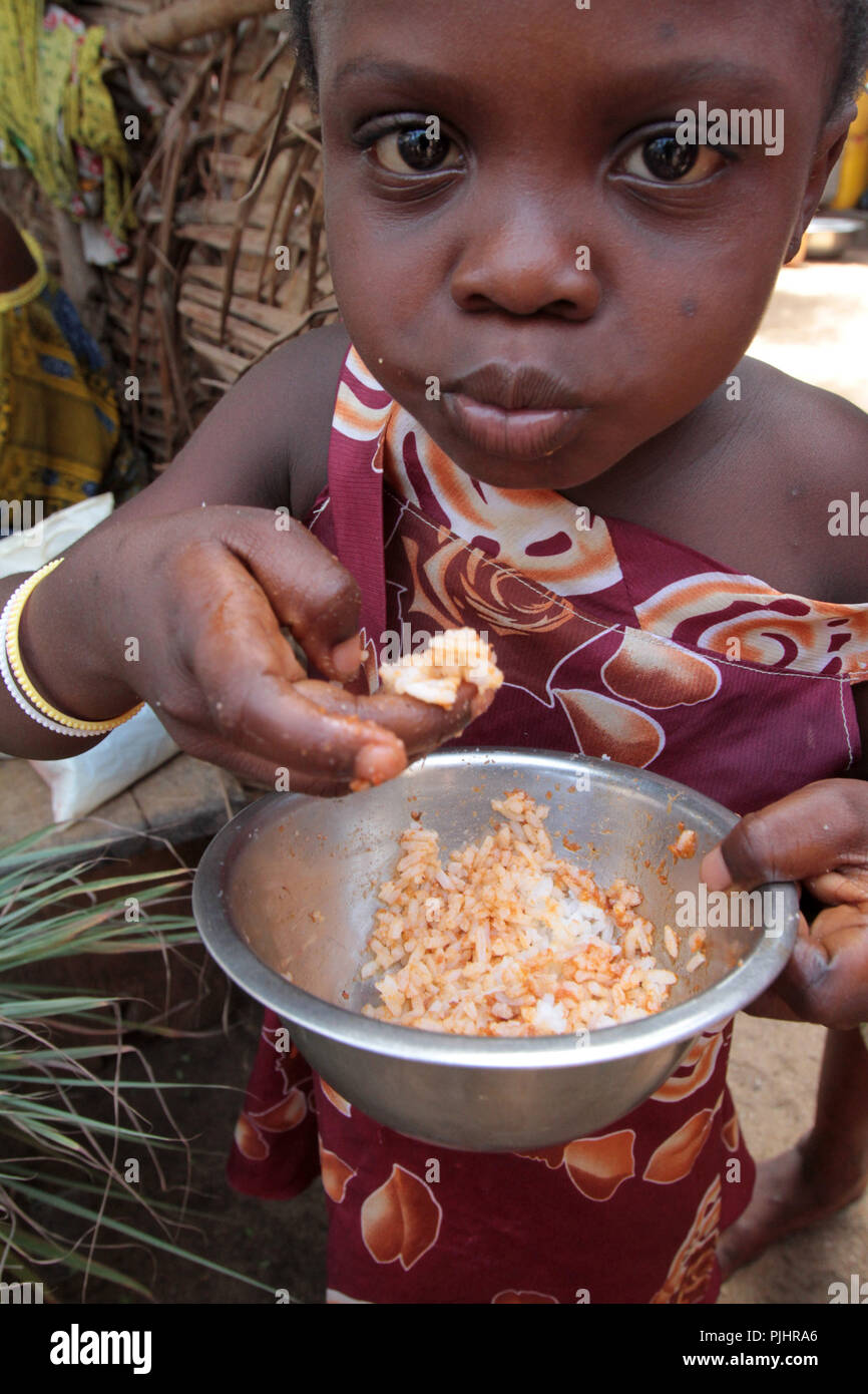 small-togolese-girl-eating-a-bowl-of-rice-with-hands-lome-togo-PJHRA6.jpg