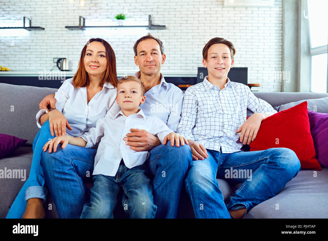 Four People Sitting On Couch Stock Photos Four People Sitting On