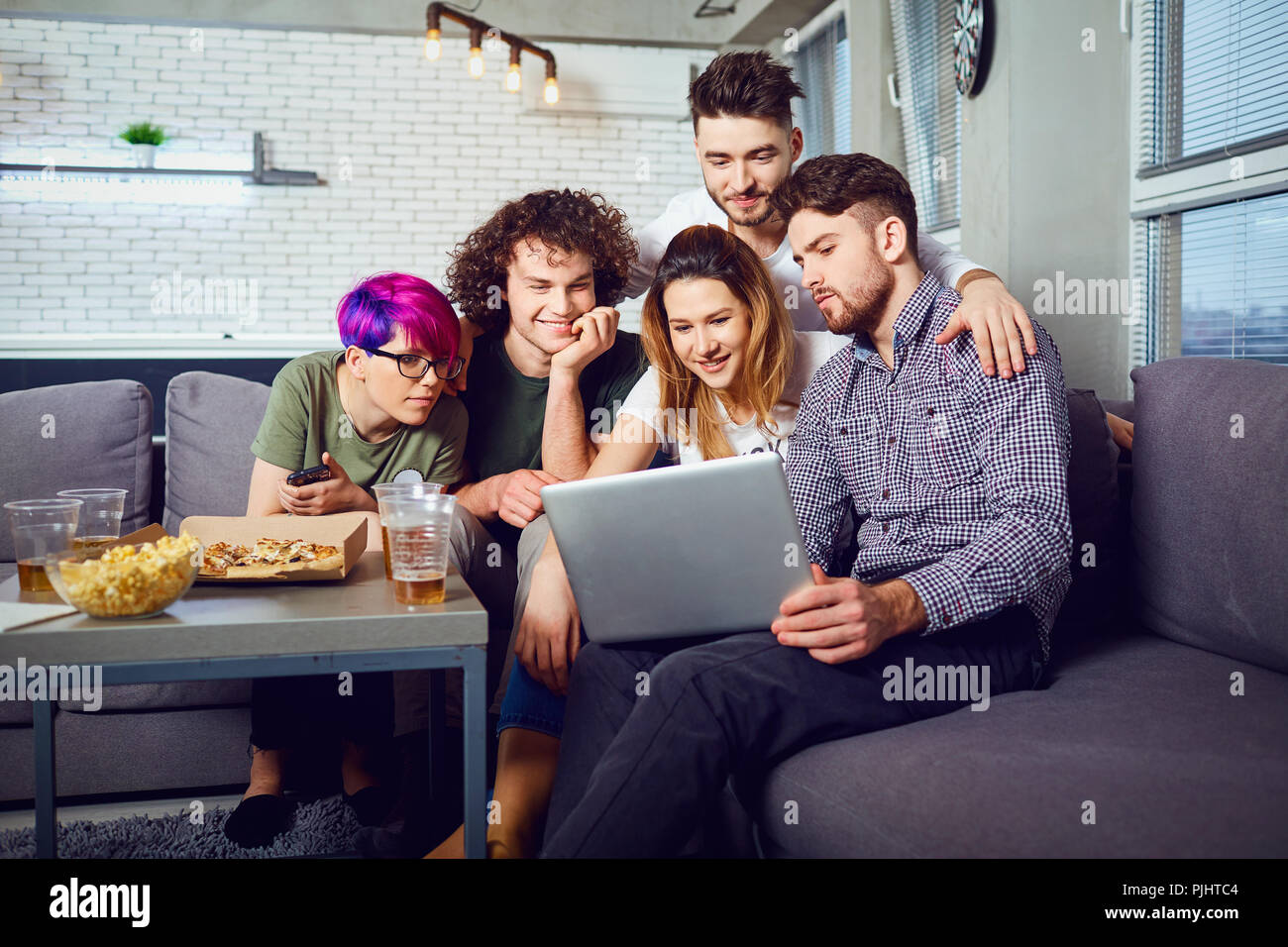 A group of friends of students in leisure with a laptop in a roo Stock Photo