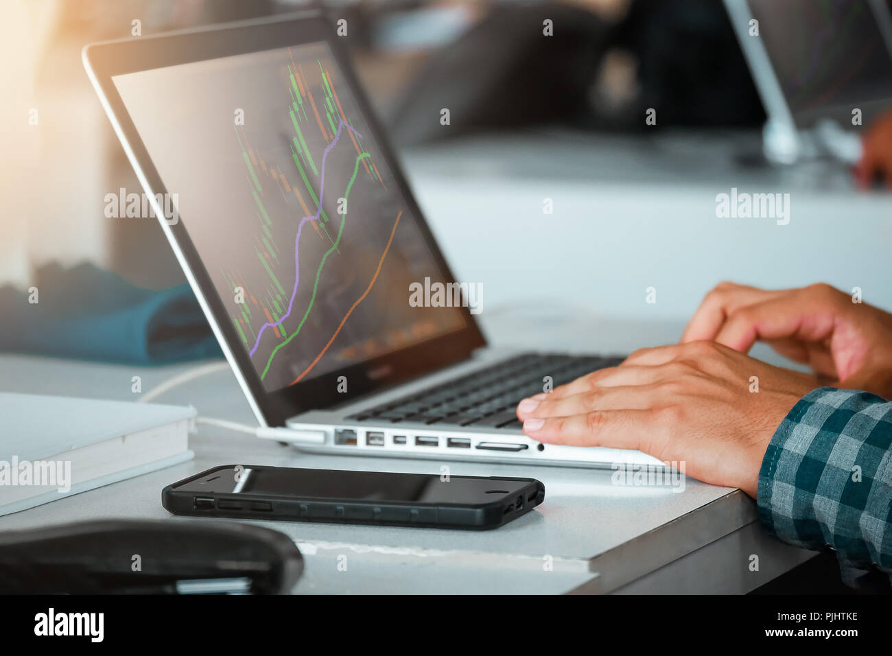 Close up of man using laptop trading stock exchange market in coffee cafe Stock Photo