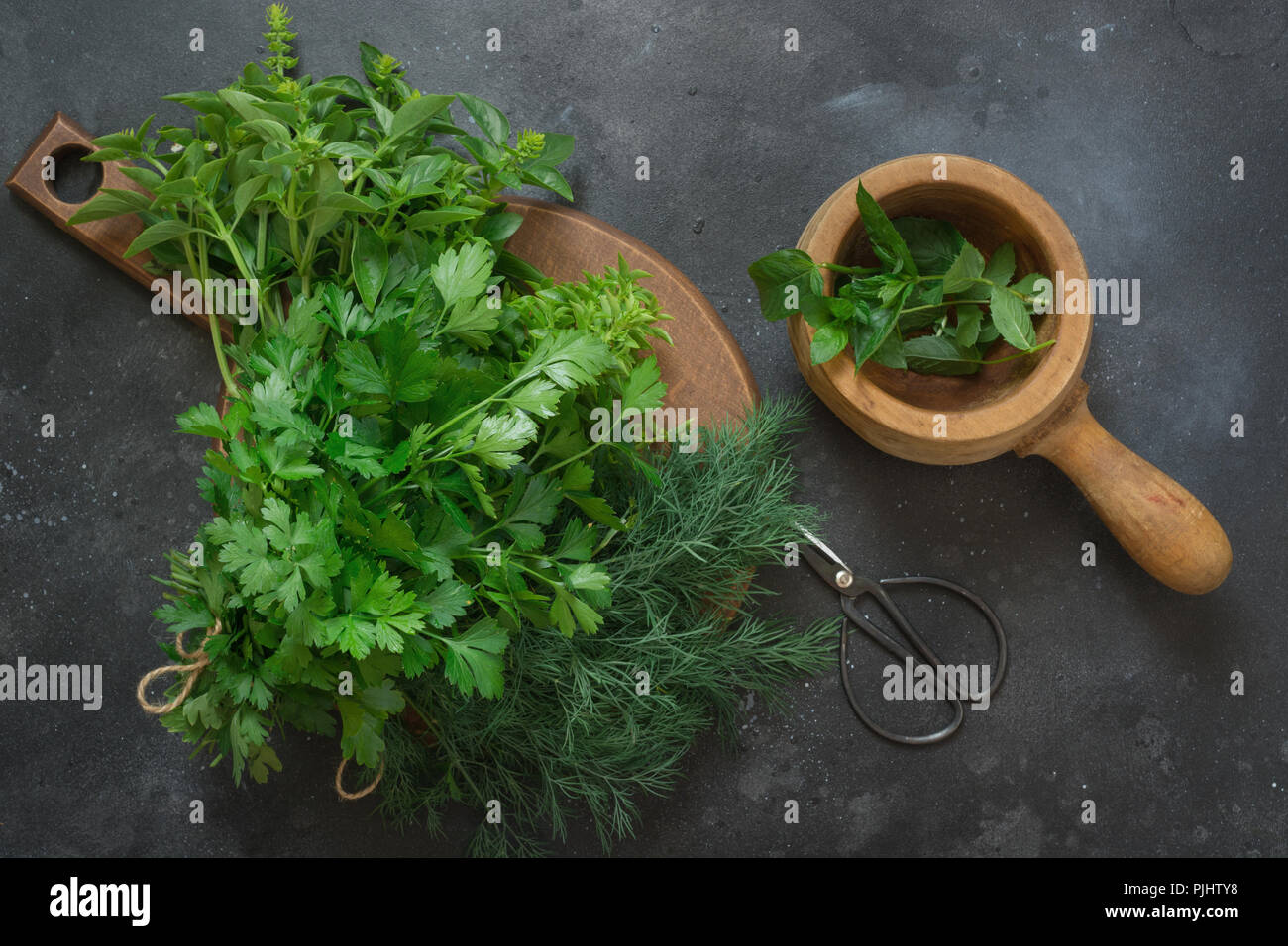 Fresh bundle of fresh herbs. Basil, mint, oregano on dark. Kitchen herbs. Stock Photo