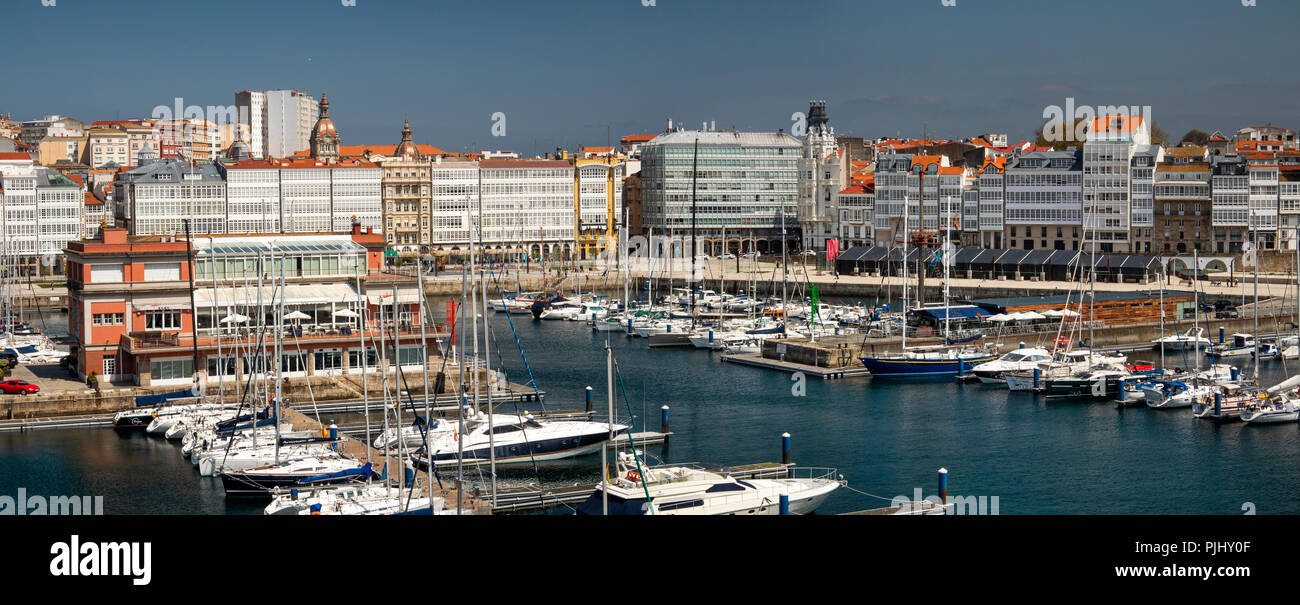 Spain, Galicia, A Coruna, harbour, waterfront park and marina by glazed waterfront buildings, panoramic Stock Photo