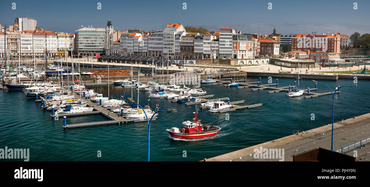 Spain, Galicia, A Coruna, harbour, waterfront park and marina by glazed waterfront buildings, panoramic Stock Photo