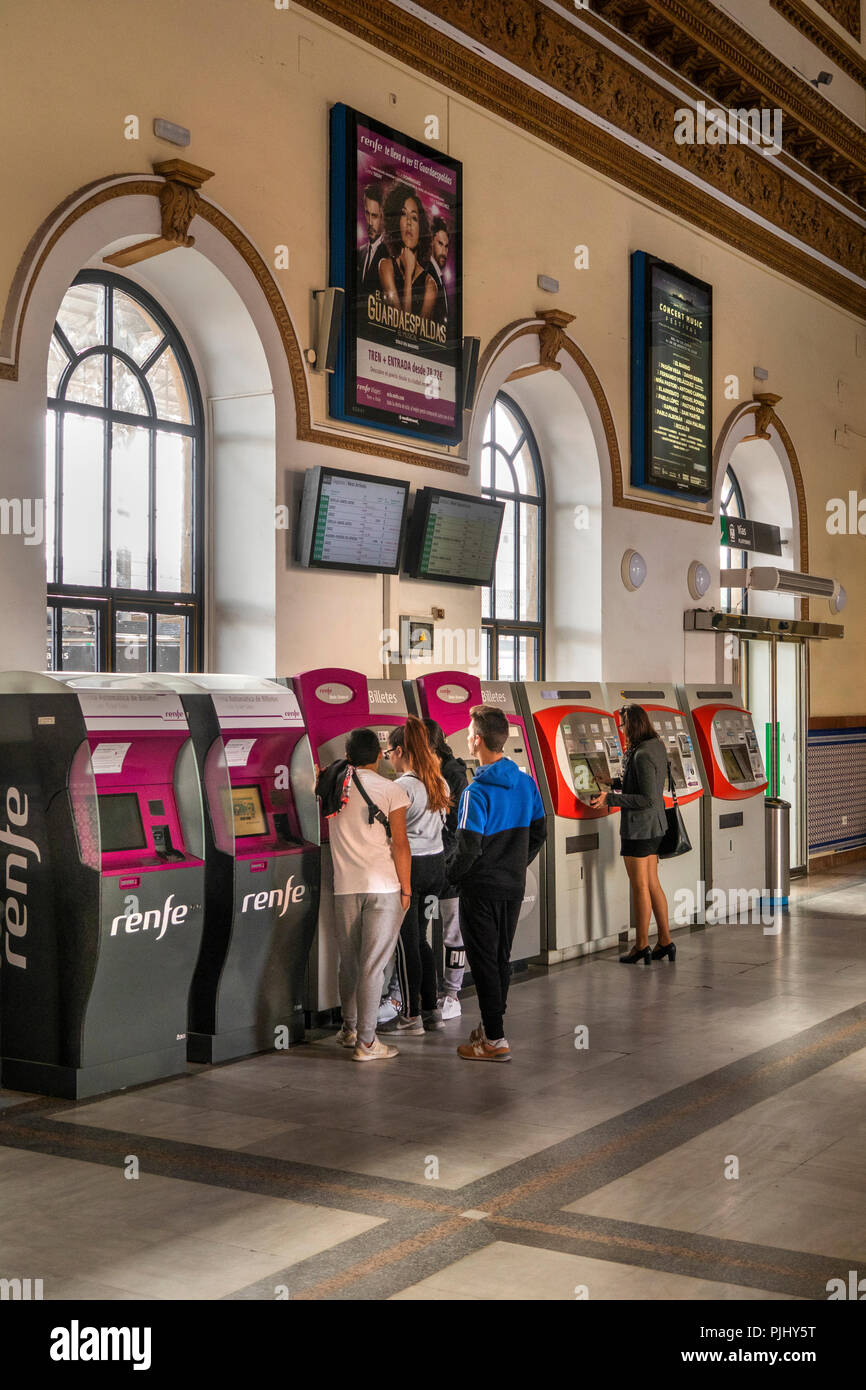Spain, Jerez de La Frontera, Train Station, interior passengers buying tickets at automated machines Stock Photo