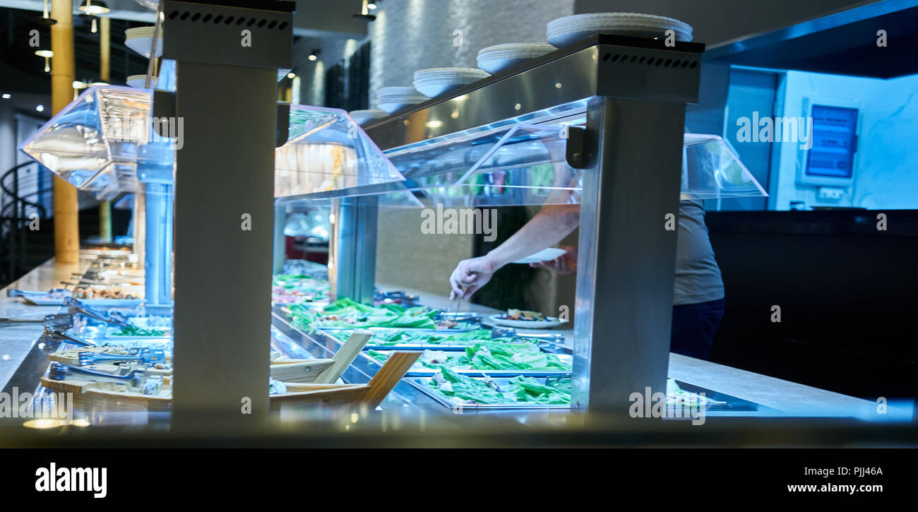 closeup of a person choosing food from a buffet Stock Photo