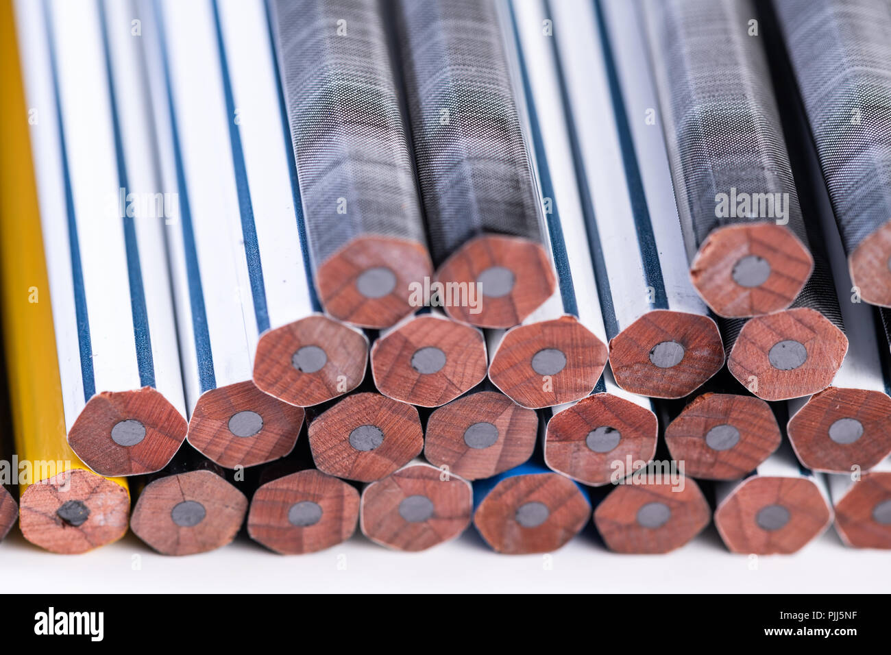 Several unsharpened new graphite pencils of different colors and patterns Stock Photo