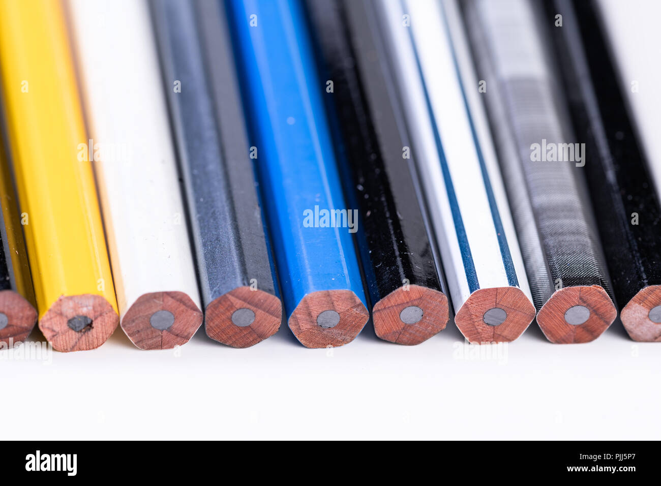 Several unsharpened new graphite pencils of different colors and patterns Stock Photo