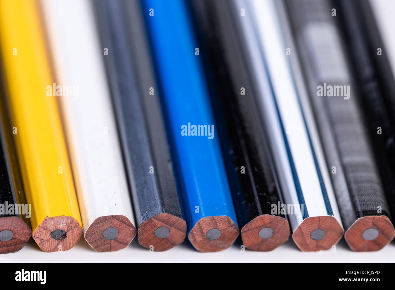Several unsharpened new graphite pencils of different colors and patterns Stock Photo
