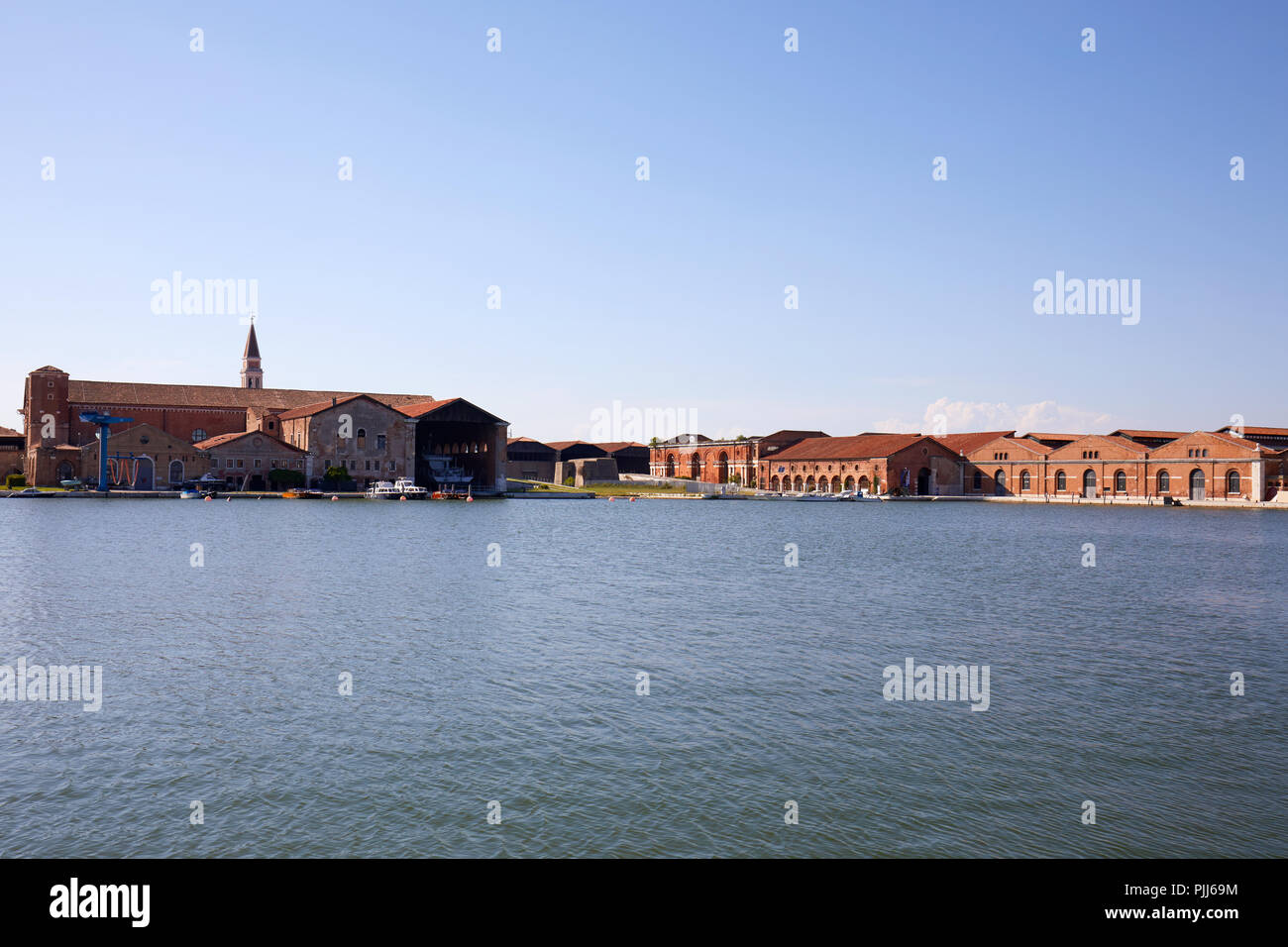 Venetian Arsenal shipyard, canal and industrial red bricks buildings in a sunny day in Venice, Italy Stock Photo