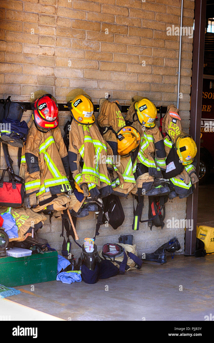 Uniforms of Firemen and women hanging on the wall inside a Fire station in Tucson, AZ Stock Photo