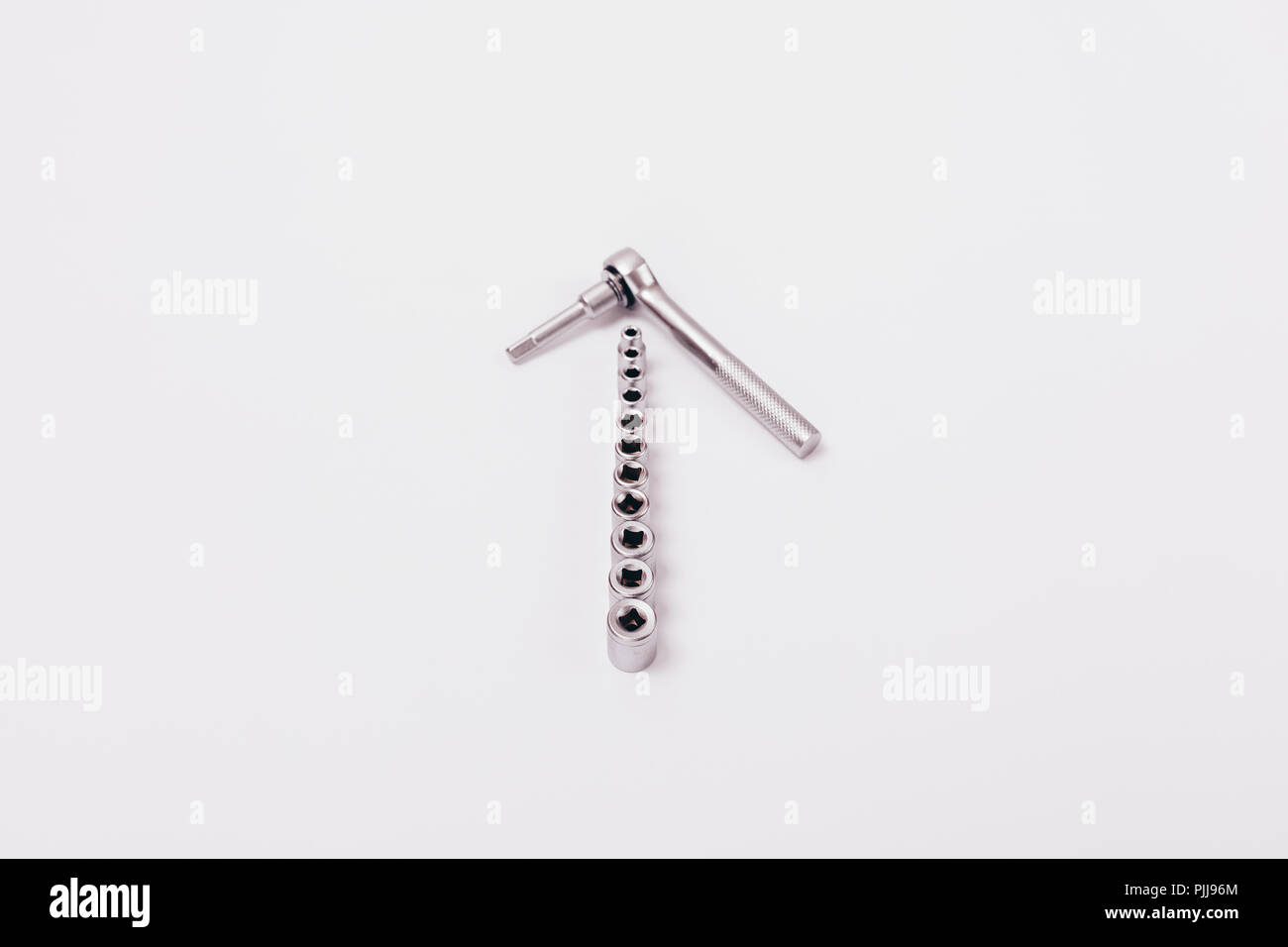 Spanner and various attachments. Composition of metal hand tools on a white background. Stock Photo