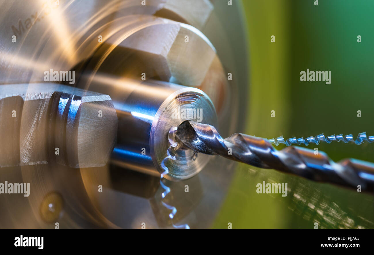Drilling on lathe closeup. Metal shavings. Metallic workpiece clamped