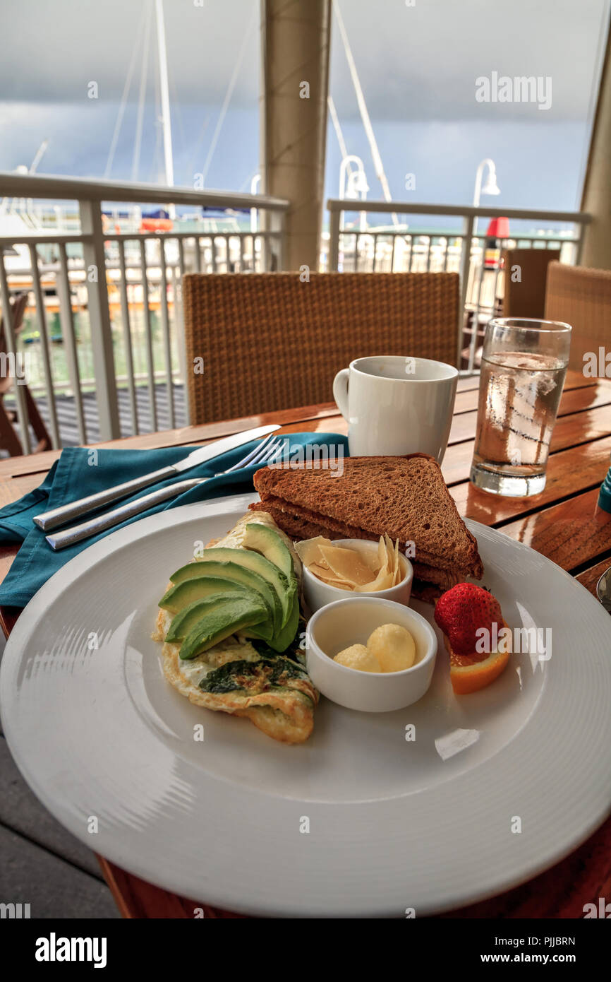 Egg white omelet with spinach, avocado slices and cheese along with wheat toast and butter for