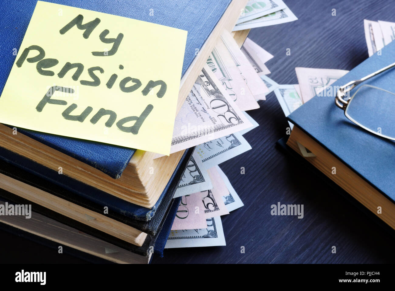 My pension fund. Books with dollar bills and glasses. Stock Photo