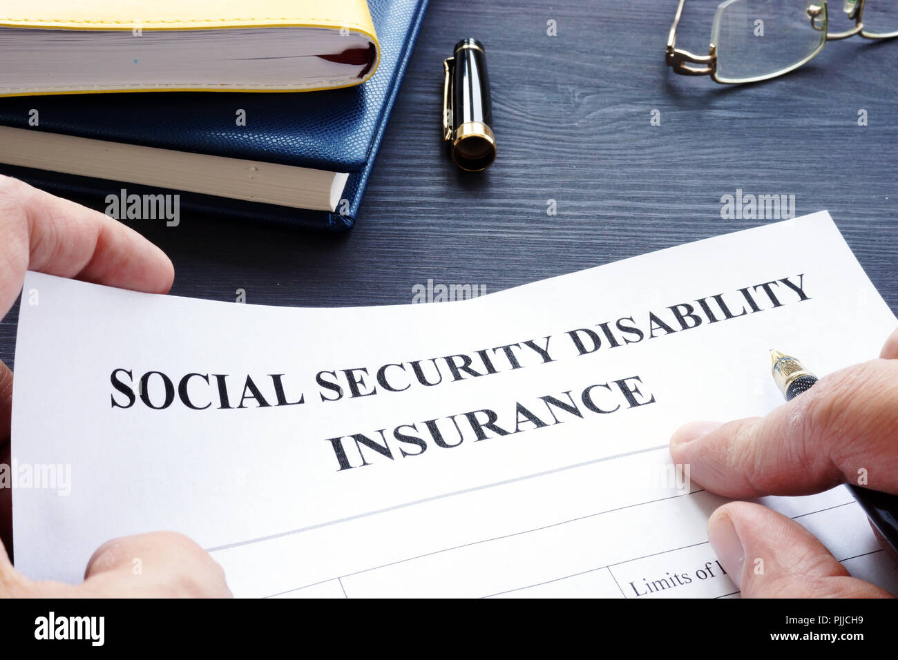Man is holding Social Security Disability Insurance SSDI policy. Stock Photo