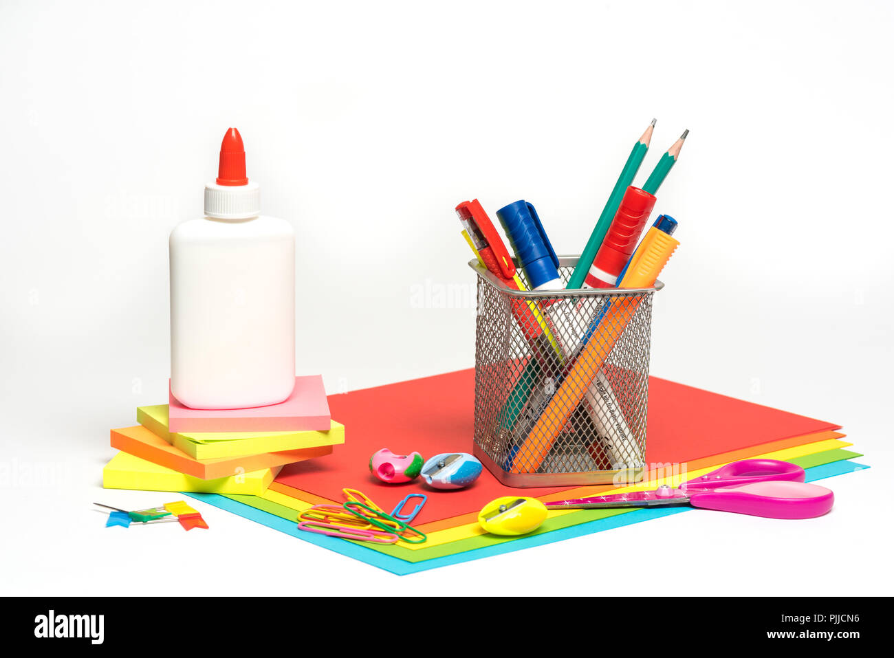 White background with stationery items - paper, pens, sharpeners, scissor, glue, paper clip , sticky notes and paper Stock Photo