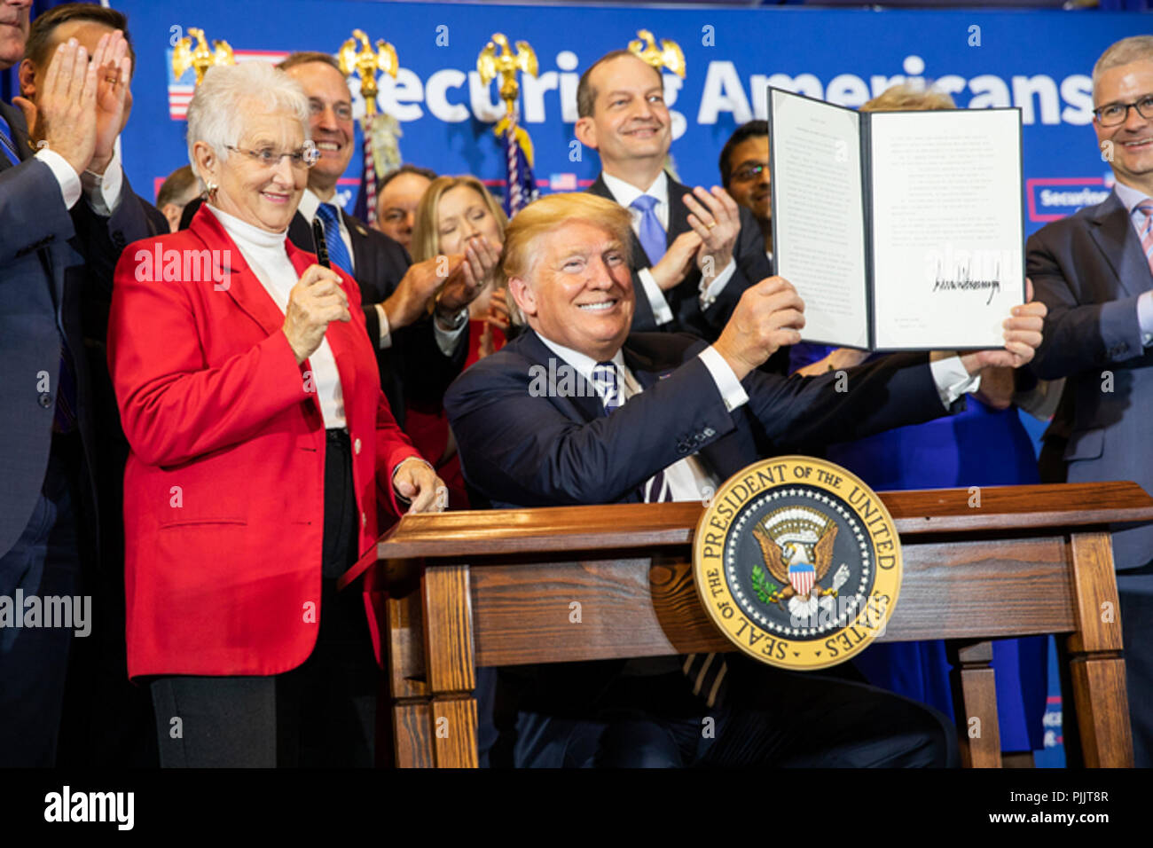 President Donald J. Trump is applauded as he displays his signature after signing the Executive Order on Strengthening Retirement Security in America on Friday, August 31, 2018, at the Harris Conference Center in Charlotte, North Carolina.  People:  President Donald Trump Stock Photo