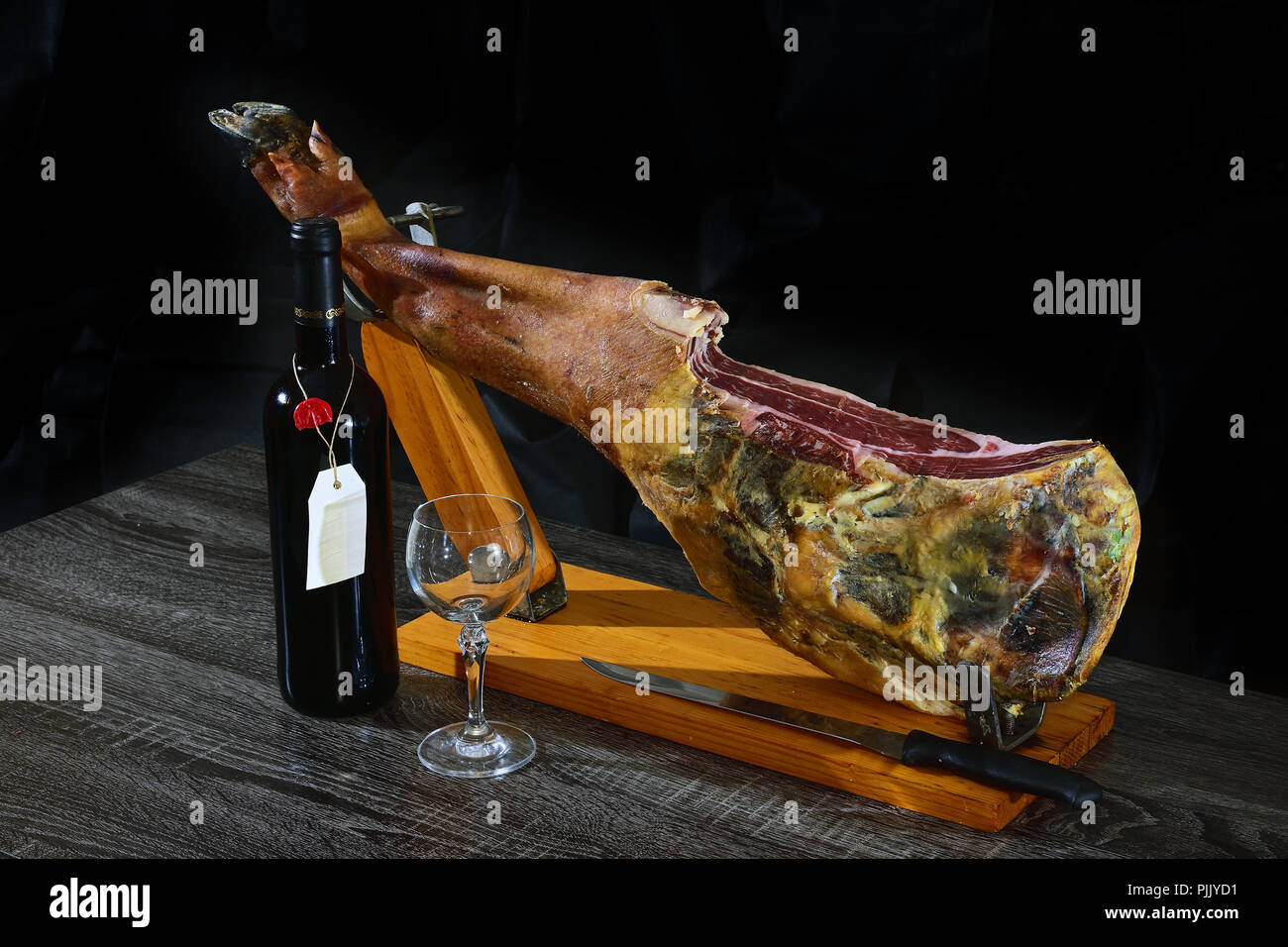 Spanish Jamon Serrano, tabla jamonera, jamonero knife with glass and bottle  of wine. Food photo concept Stock Photo - Alamy